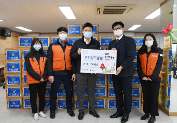 명지성모병원 김동철 행정부원장(사진 왼쪽에서 세 번째)과 대림2동 차문철 동장(사진 오른쪽에서 두 번째)을 비롯한 명지성모병원 직원들이 12월 4일 영등포구 대림2동 주민센터에 지역의 소외된 이웃을 위해 준비한 라면 150박스를 전달한 후 기념사진을 찍고 있다.