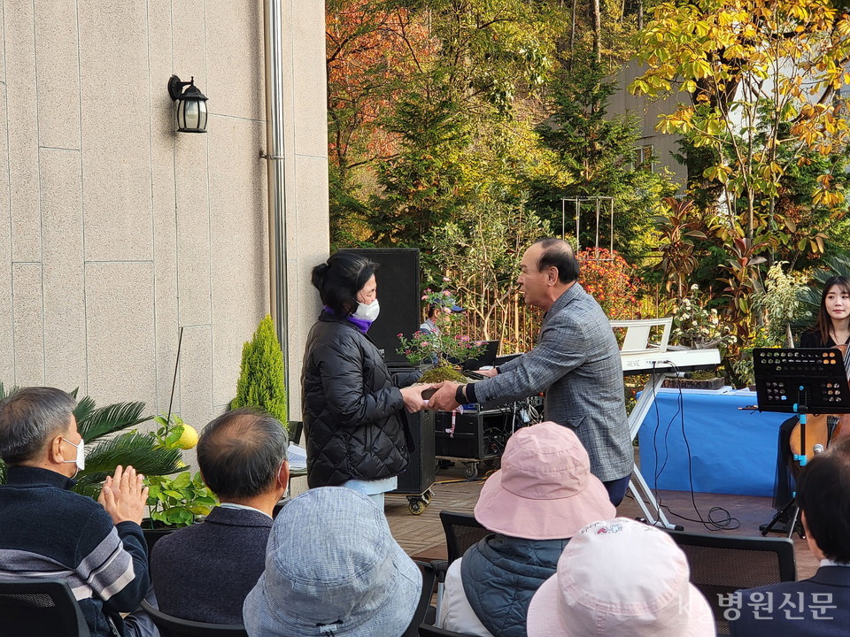 윤세권 원예심리상담실장이 환우에게 동료 환우가 만든 국화분재를 전달하고 있다. ⓒ병원신문