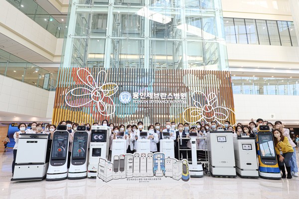 11월 17일 용인세브란스병원 1층 로비에서 개최된 의료서비스로봇 소개 행사에 참여한 교직원들이 6종 11대의 의료서비스로봇과 함께 단체사진을 찍고 있다.