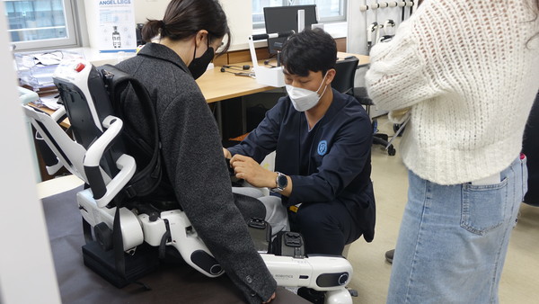 워크숍 참가자가 재활로봇을 직접 착용하며 체험하고 있다.