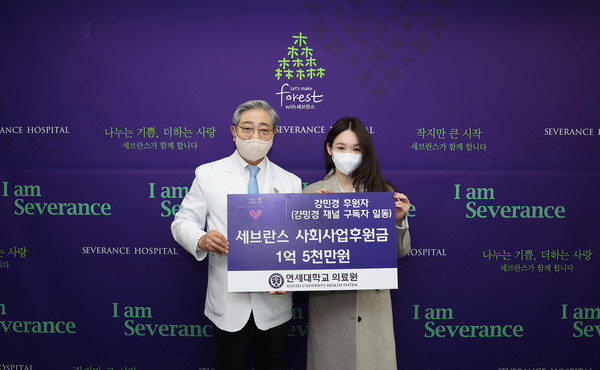윤동섭 연세대학교 의료원장(사진 왼쪽)과 가수 강민경 씨가 기부 판넬을 들고 기념 촬영을 하고 있다.