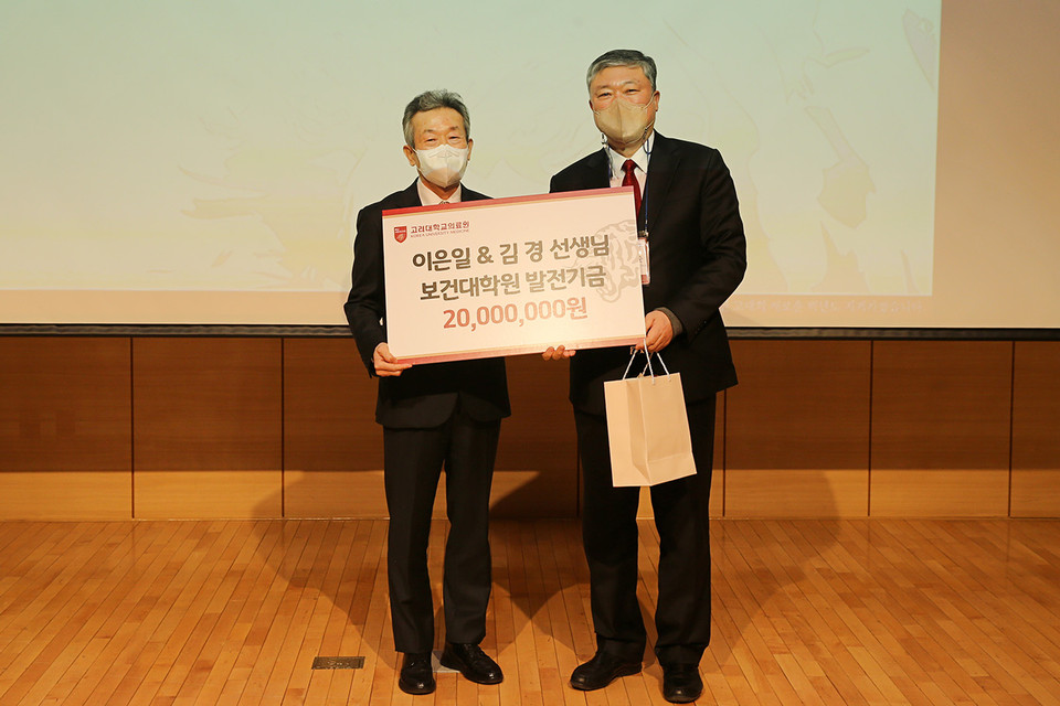 이은일 교수 (왼쪽)가 보건대학원 발전기금을 전달한 뒤 윤석준 보건대학원장(오른쪽)과 기념촬영을 하고 있다.