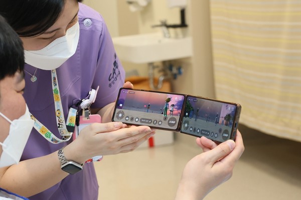중앙대광명병원 간호사가 입원 환자에게 메타버스 해돋이 모습을 보여주고 있다.