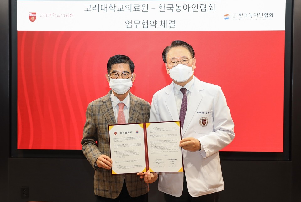 고려대의료원 김영훈 의무부총장(우측)과 한국농아인협회 변승일 중앙회장(좌측)이 협약서에 서명 후 기념촬영을 하고 있다.