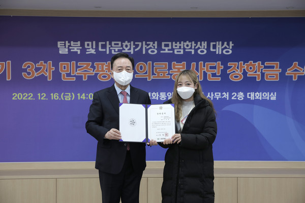 탈북민 및 다문화가정 자녀에게 장학금을 수여하는 민주평통 김철수 의료봉사단장(사진 왼쪽)