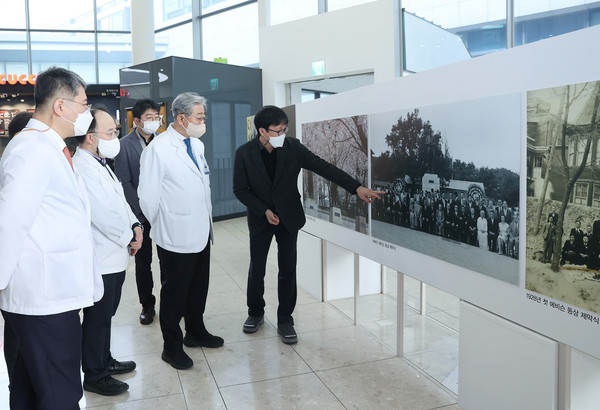 윤동섭 의료원장(사진 오른쪽 두 번째)이 2월 1일 에비슨 동상 사진 전시회에서 사진을 관람하고 있다.