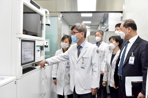 화순전남대학교병원 정용연 병원장(가운데) 등이 마약류 안전관리를 위해 도입한 전자동 약품 분배캐비닛 시스템인 인티팜(INTIPharm)을 살펴보고 있다.