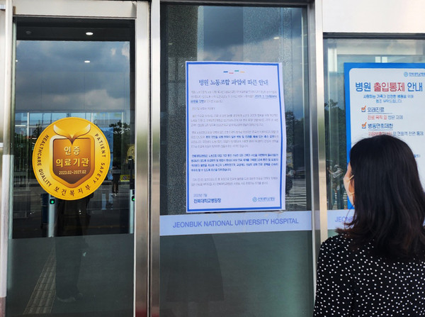병원 내원객이 전북대병원 본관 출입문에 게재된 노동조합 파업에 따른 병원 안내문을 읽고 있다.